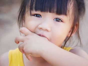 Close-up portrait of cute baby licking finger