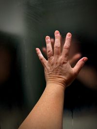 Close-up of hand touching glass