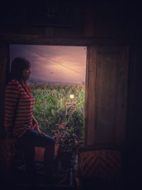 Side view of woman looking at plants