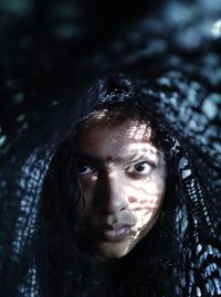 Close-up portrait of woman in darkroom