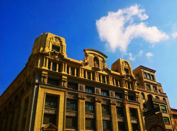 Low angle view of building against cloudy sky