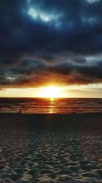 Scenic view of sea against cloudy sky at sunset