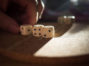 Close-up of hands playing dice on table