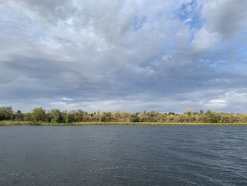 Scenic view of lake by trees against sky