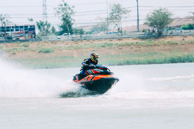 Man riding motorcycle on boat in water