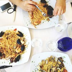 Cropped image of woman eating food on table