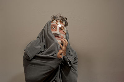 Man holding mask against orange wall