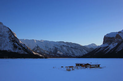 Scenic view of snowcapped mountains against clear blue sky