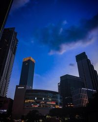 Low angle view of illuminated buildings against sky at dusk