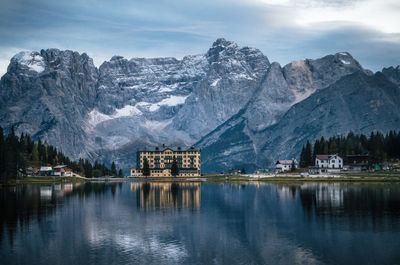 Scenic view of lake by snowcapped mountains against sky