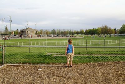 Rear view of woman on field against sky