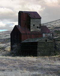 Abandoned building on field against sky