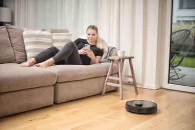 Young man using mobile phone while sitting on sofa at home