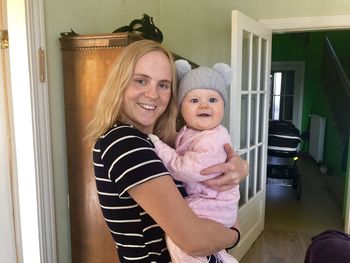 Portrait of happy mother with baby at home