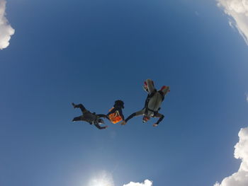 Low angle view of man jumping against sky