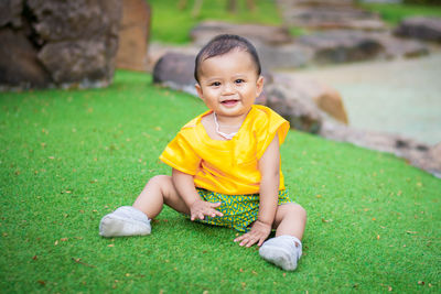 Portrait of the cute boy sitting on the grass