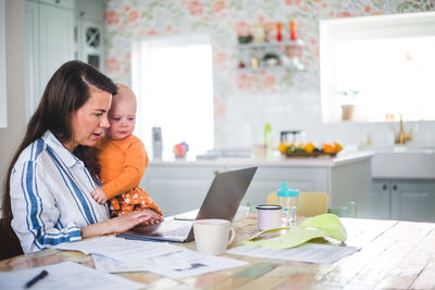 Mother and son using smart phone on table