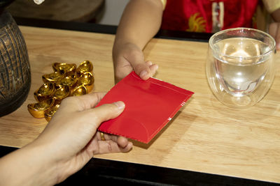 High angle view of woman hand holding book on table