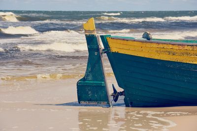 Cropped image of boat moored at beach