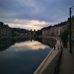 River amidst buildings in city against sky