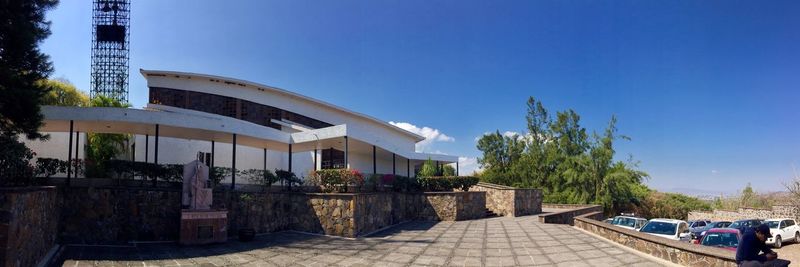 View of swimming pool by building against clear blue sky