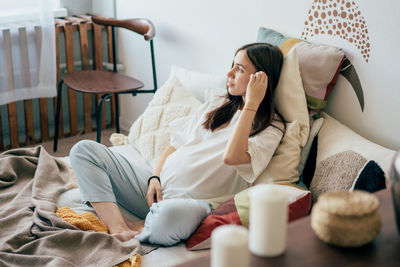 Pregnant woman resting on bed at home