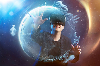 Man wearing virtual reality simulator touching earth