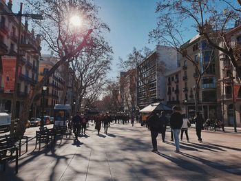 People walking on street amidst buildings in city