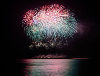 Firework display over sea at night