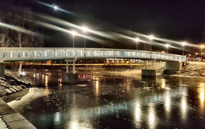 Illuminated bridge over city at night