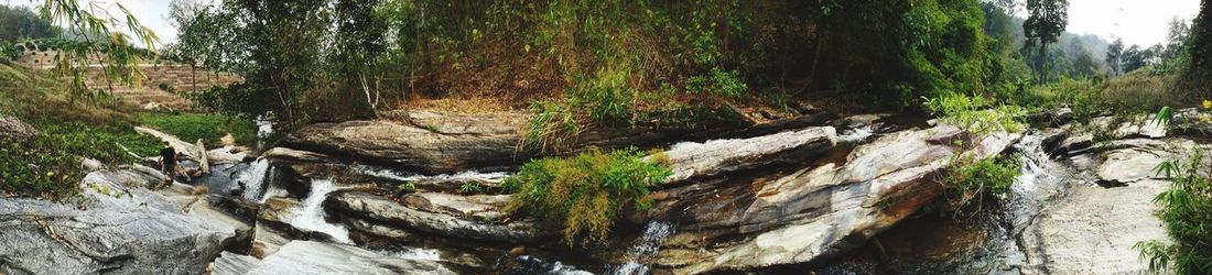 Panoramic view of stream flowing through rocks