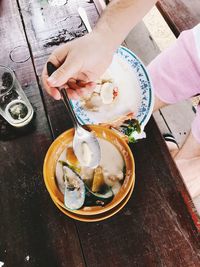High angle view of hand holding ice cream on table