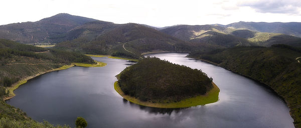 Scenic view of river and mountains against sky