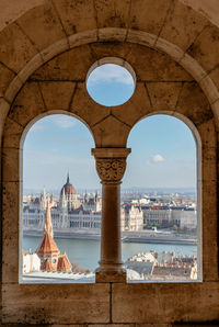 View of city of budapest through arches of fisherman's bastion on a sunny day