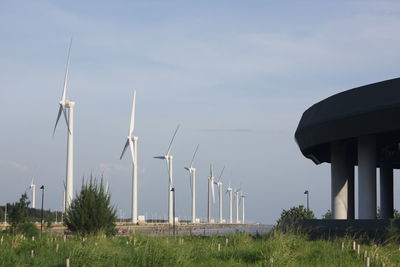 Windmills on field against sky