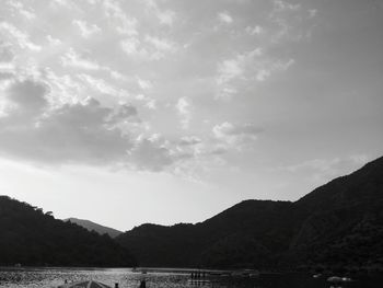 Scenic view of sea and mountains against sky