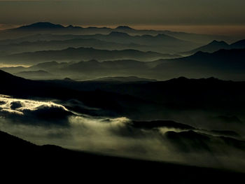 Scenic view of silhouette mountains against sky at sunset