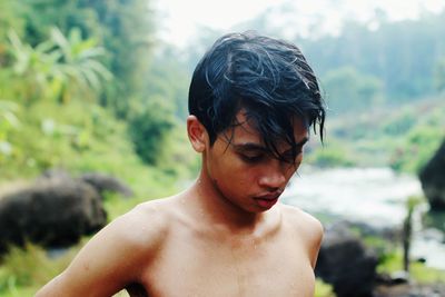 Close-up portrait of shirtless young man