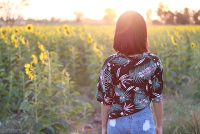 Rear view of woman standing on field 