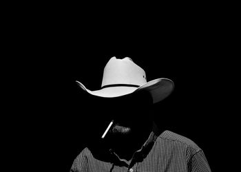 Man wearing hat against black background