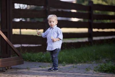 Full length portrait of young man standing against wall