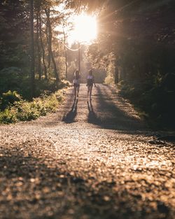 Rear view of people walking in forest