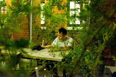 Man sitting on table at yard