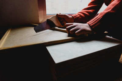 Cropped hands cutting wood in workshop