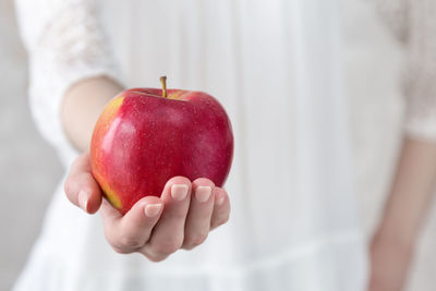 Midsection of woman holding apple