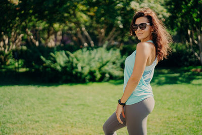 Portrait of woman wearing sunglasses exercising in park