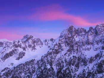 Scenic view of snowcapped mountains against sky at sunset