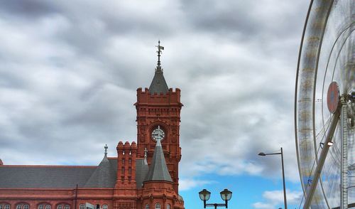 Low angle view of clock tower against cloudy sky