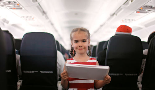 Portrait of smiling boy holding airplane in bus