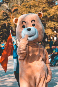 Person in bear costume standing on footpath in park